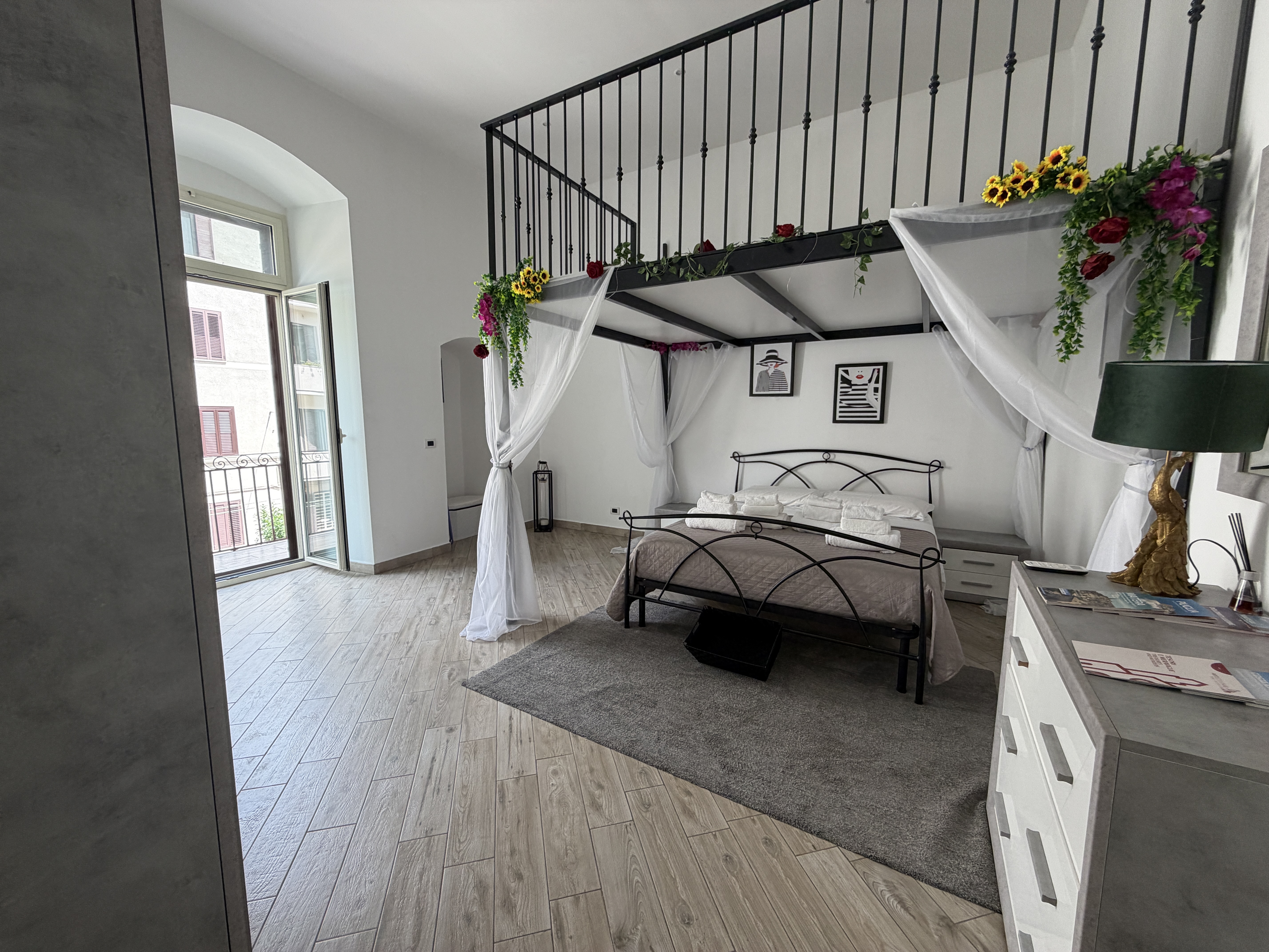 Camera romantica della Maison di Eva con veli bianchi e letto in ferro